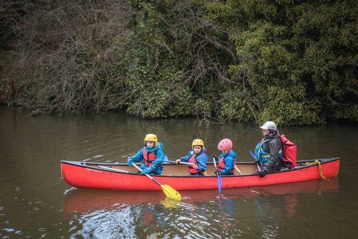 a group of people riding on the back of a boat in the water