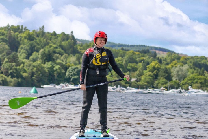 a man riding on the back of a boat in a body of water