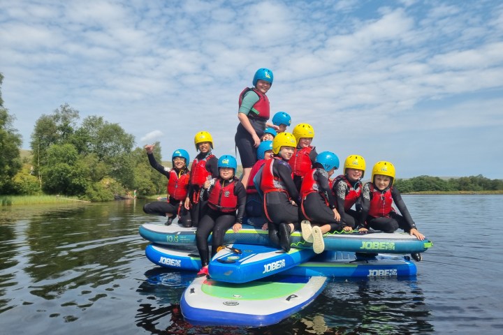 a group of people riding on the back of a boat in the water