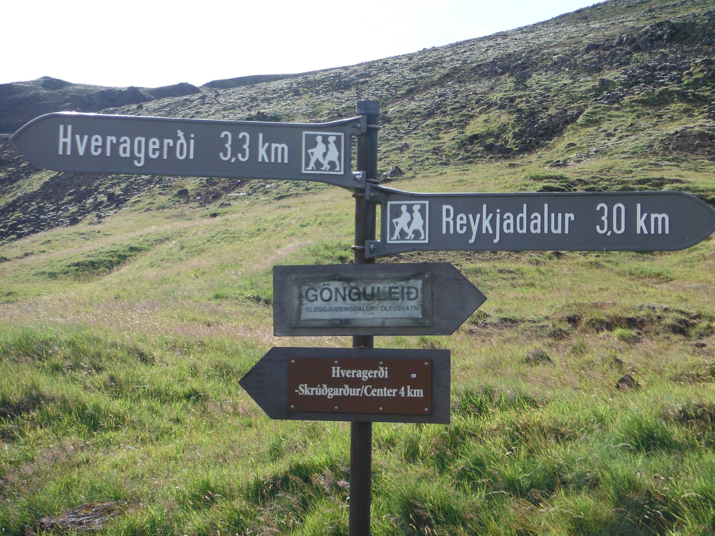 a sign on the side of a lush green field